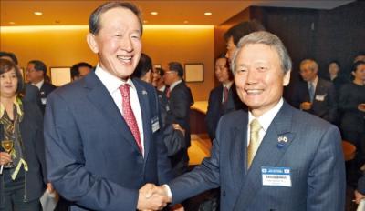 全国経済人連合会の許昌秀（ホ・チャンス）会長（左）が日本経団連の榊原定征会長と握手している。