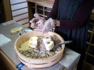 平家の赤旗をイメージした「おまん小豆おにぎり」を握るスタッフの伊藤さん 平家の赤旗をイメージした「おまん小豆おにぎり」を握るスタッフの伊藤さん